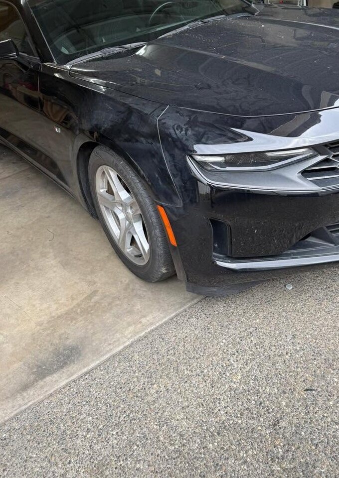 Black Chevrolet Camaro with glossy paint in a garage